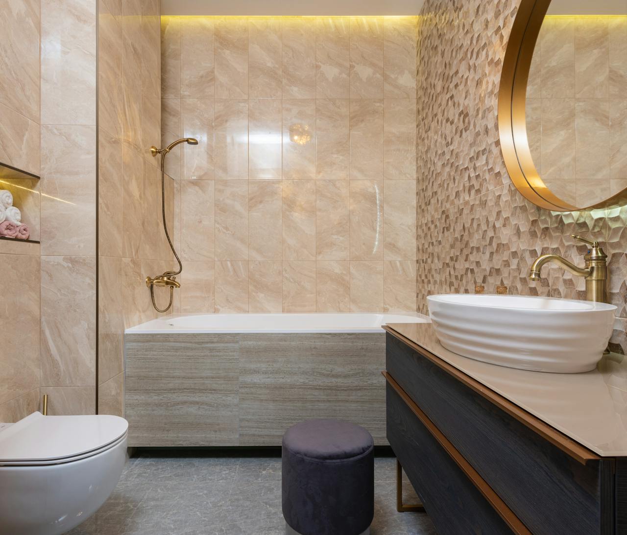 Contemporary bathroom with toilet bowl against washbasin on cabinet under mirror reflecting tiled wall in hotel